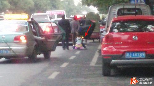 车来车往中，拖着孩子在机动车道上穿行真是很危险（网友供图）