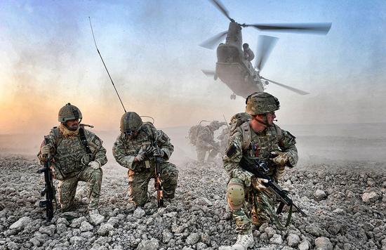 这张照片是中士鲁珀特·弗里尔（Rupert Frere）拍摄的，英军士兵与阿富汗警察在赫尔曼德省重新建立政府控制区，士兵们正在直升机掩护下建立阵地。（网页截图） 