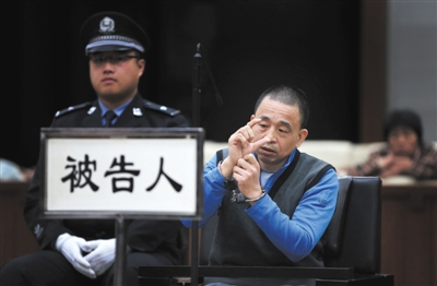 昨日,北京二中院。法庭上,犯罪嫌疑人黄志亮,比划凶器锤头的大小。 新京报记者 尹亚飞 摄