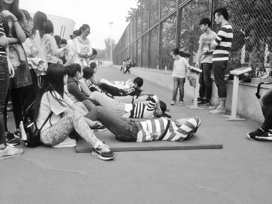 在山大体育场,女生在测试仰卧起坐。 (许亚薇 摄)