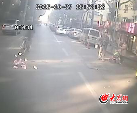 騎自行車(chē)小伙掉錢(qián)的一剎那。