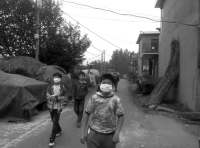 路过的小学生戴口罩躲避刺鼻气味