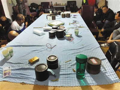 警方缴获蛐蛐20余只，现场还摆放着饲料盒等物品。