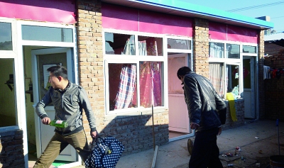 另一个传销大院已人去楼空,愤怒的家属将门窗的玻璃砸碎 摄/记者 董振杰