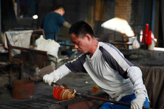 淄博市淄川区振华玻璃制品厂正在制作琉璃的“艺术家们”