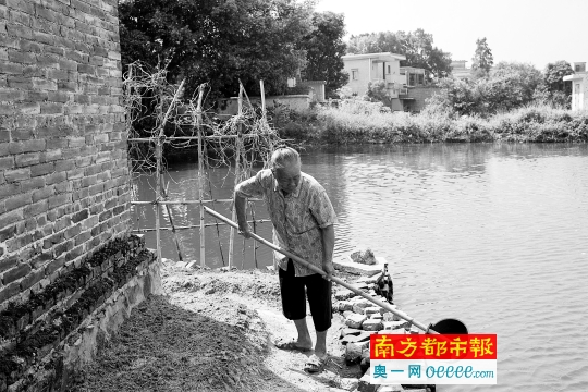 83岁的杜六妹在为蔬菜浇水,她一人居住,无人照顾。