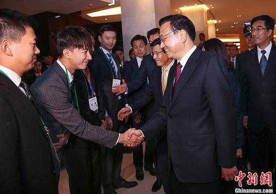 这是两国总理会见青年代表时，李克强与韩庚交谈。中新社记者 刘震 摄