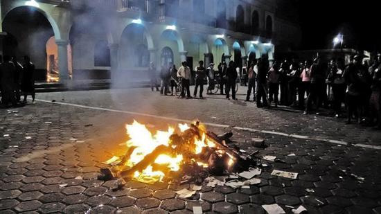 墨西哥两名学生被误当成绑匪，被居民滥用私刑烧死，警方在场围观。(网页截图)