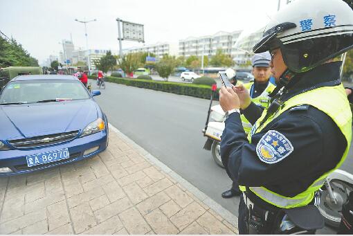1日，交警向经十路一违法停车的车辆开出首张罚单。 记者谢永亮摄