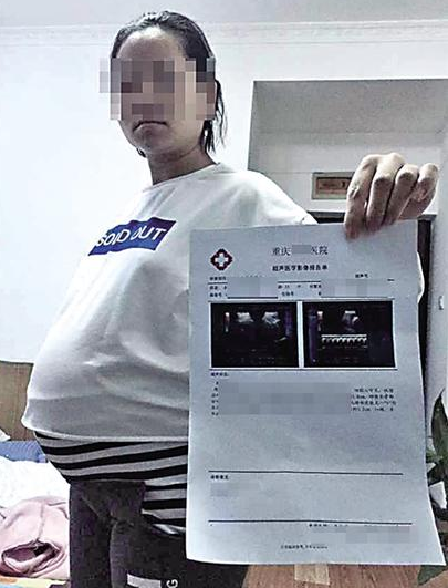 昨日,大渡口区,李小姐在展示产检报告。记者 龙在全 摄