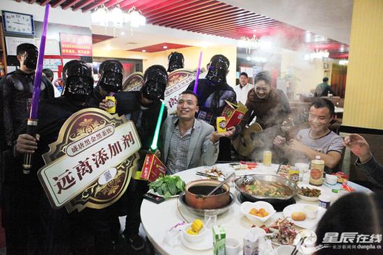 11月1日晚,长沙湘江世纪城某夜宵城,一位被“劫”的食客和黑金武士合影,一起呼吁“远离添加剂”。