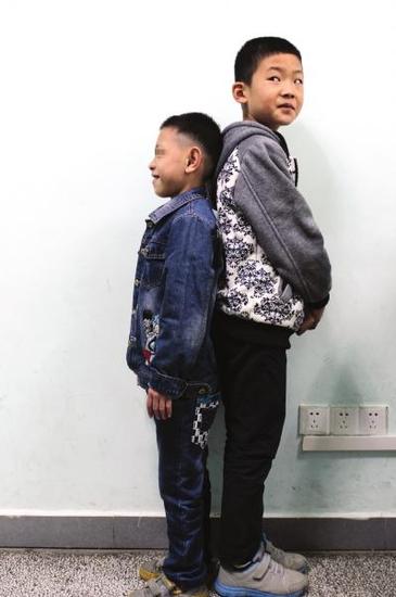 11月2日，湖南省儿童医院，陈尚义（左）跟旁边男孩相比明显矮小不少。 图/记者陈正