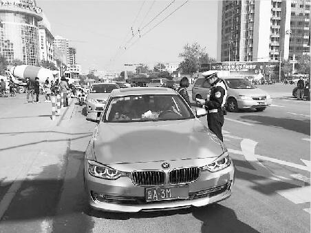 民警将一辆不礼让行人的轿车拦下，并对其开具罚单。 记者陈延鹏 摄