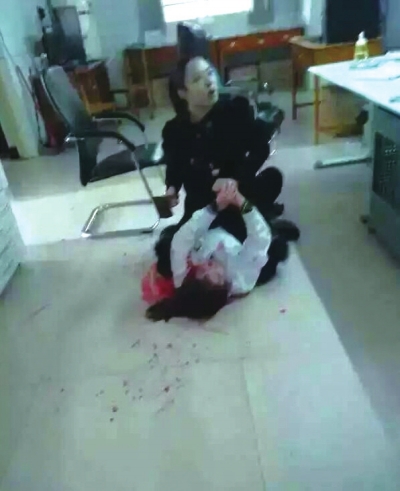 嫌疑人手持菜刀骑在一名女医生身上。数厘米长伤口横贯左脸颊。