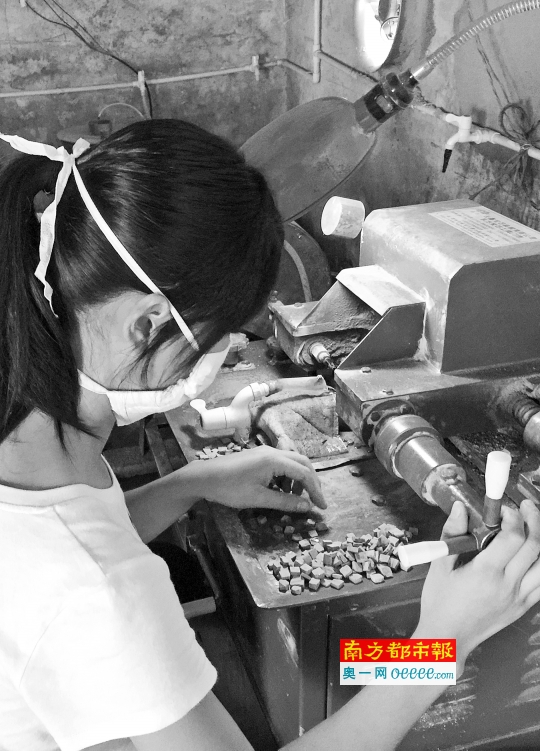 一名女工正在小作坊加工石器。