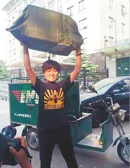 邓女士举起了一个二十斤重的大包裹。