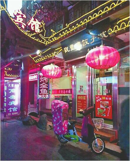 观丰楼饺子城广告牌显示特价烤鱼38元/条 记者张丹丹 摄