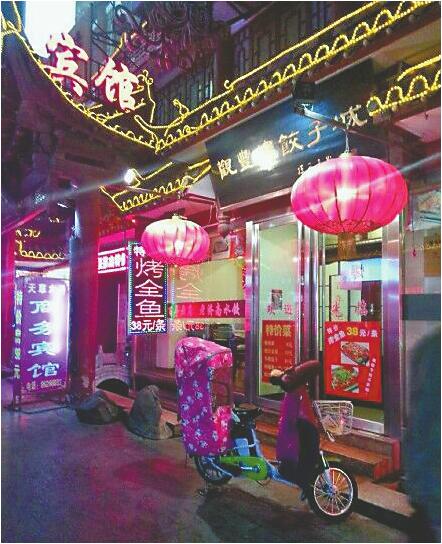 觀豐樓餃子城廣告牌顯示特價烤魚38元/條 記者張丹丹 攝