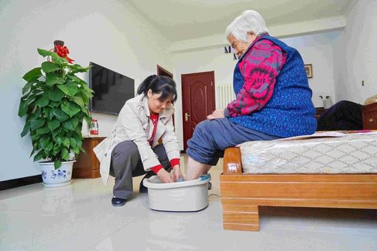白延琴在家给婆婆洗脚的场景。水峪嘴村供图