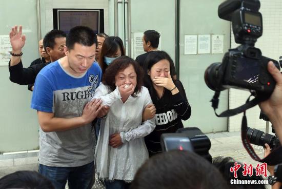 图为10月22日，疑被袭击致死的内地游客苗春起的妻子（中）、女儿（右）、女婿（左）等家属，在香港葵涌殓房办理认领遗体手续。中新社记者 张宇 摄