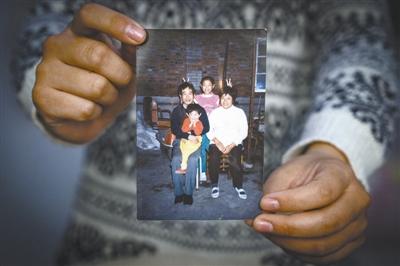 李雪3岁时，一家四口照了全家唯一的一张合照。父亲去世后，这张照片更显珍贵。本报记者 王伟伟摄