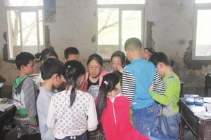 广安华蓥顺天寨村小女教师何昌芳给学生批改作业。