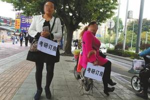 11月9日，四川师范大学外，两名手持“考研订房”的女子。