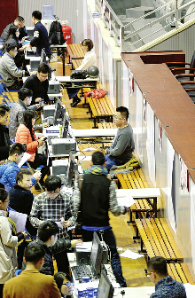 7日，在皇亭体育馆，众多考生现场拍照进行考研登记确认。