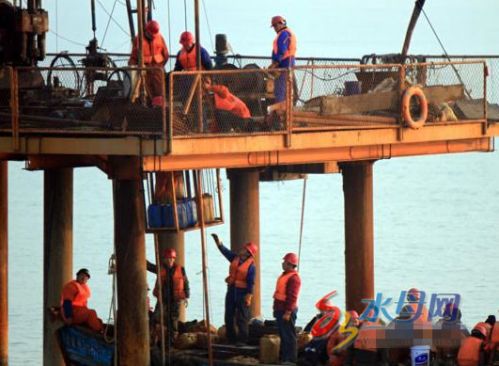 勘探现场,数个橙红色的海上钻探平台直插入海