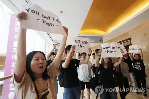 22日,动物保护人士在炸鸡鉴别师大会会场外抗议(图:韩联社)