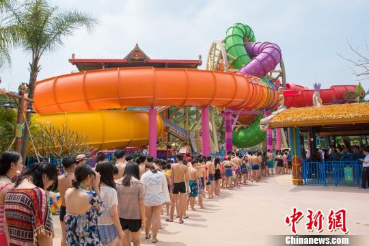 广州长隆水上乐园1日开启2018年玩水季,园方从德国原装引进全球首创、仅此一台的“摩天旋转滑道”,游客大排长龙、争相体验。 麦念萍 摄
