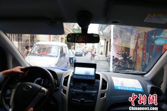 行走小巷的微公交车。 王晓斌 摄