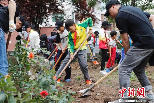 孩子们与空客中国公司的志愿者一起种下绿色植物。 殷立勤 摄