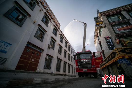 18米高喷消防车在火场外围高压喷水压制火势。 何蓬磊 摄 西藏消防部队开展大型商场火灾救援演练