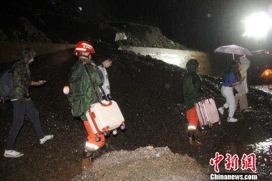 图为消防官兵帮助被困人员转移行李 唐国松 摄
