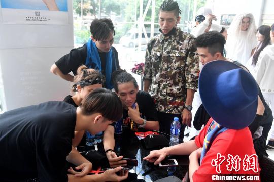台湾HiZam舞团成员们正在研究“抖音”和大陆流行的短视频平台。 吕明 摄