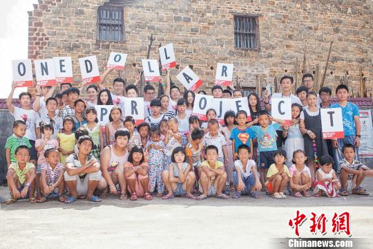 “一美元爱心计划”志愿者和江西省莲花县文塘村的孩子们。　郭仅仅 摄