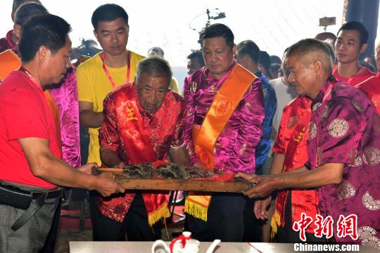 8月25日,93岁的蔡兴邦上祭品。 张丽君 摄