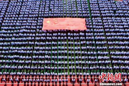 学生与国旗合影。 钟欣 摄