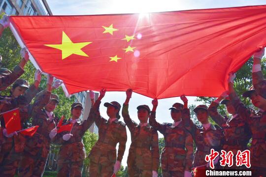 学生与国旗合影。 钟欣 摄