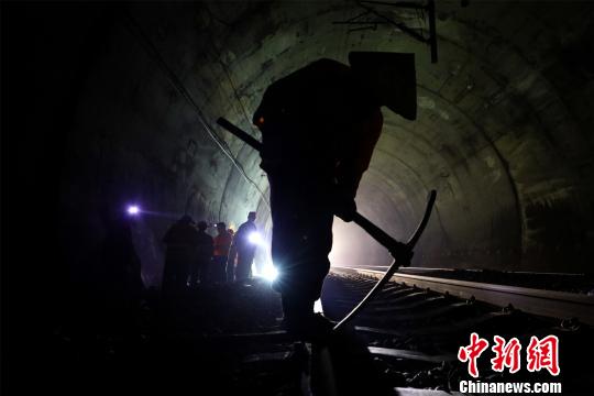 铁路工人在隧道内进行人工捣固作业。 汪翰 摄