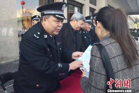 图为向民众发放宣传资料。 阿琳娜 摄 图为向民众发放宣传资料。阿琳娜 摄