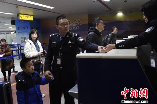 1月28日,在出境大厅,福州机场收支境边检站一名查抄员领导“无陪”儿童通关。 宋华龙 摄