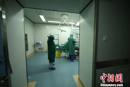 3月8日上午,在贵州省丹寨县人民医院手术室,王洪梅(左)做完三个小时的鼻息肉切除手术后准备离开。 黄晓海 摄