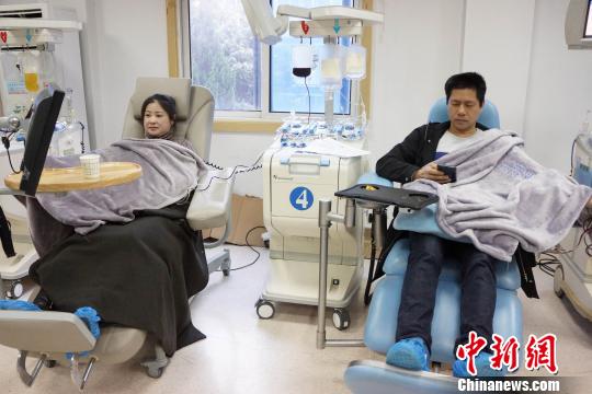 采血时间长约1小时,夫妻二人静躺在献血台上等待献血结束。 王昊阳 摄
