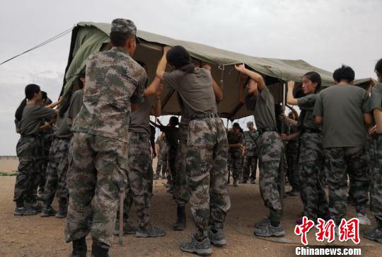 图为学生在教练指导下,搭建顶棚。 刘玉桃 摄 甘肃百余名学生暑假戈壁滩搭帐篷体验“军旅生活”