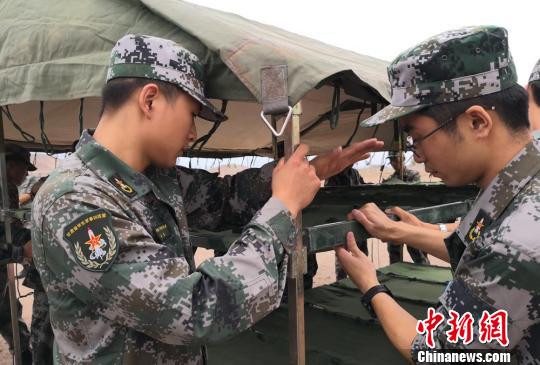 图为学生组装帐篷内的床架。 刘玉桃 摄 甘肃百余名学生暑假戈壁滩搭帐篷体验“军旅生活”