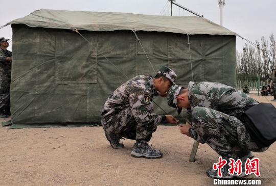 图为调整防风绳。 刘玉桃 摄 甘肃百余名学生暑假戈壁滩搭帐篷体验“军旅生活”