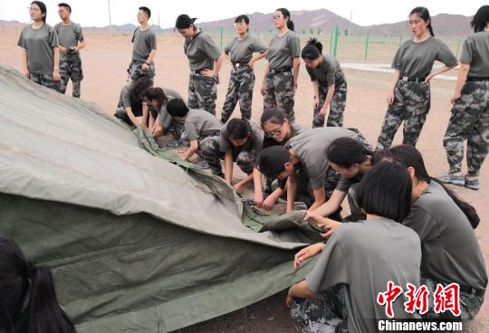 图为女生组同学搭建帐篷。 刘玉桃 摄 甘肃百余名学生暑假戈壁滩搭帐篷体验“军旅生活”