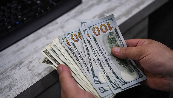 2018年5月23日，土耳其伊斯坦布尔，一名换币工作人员清点美元钞票。图片来源：视觉中国